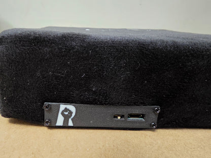 Close-up of black gaming rage pad with logo and USB ports, designed for stress relief.